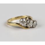 An 18ct gold and diamond three stone ring, claw set with a row of cushion cut diamonds in a