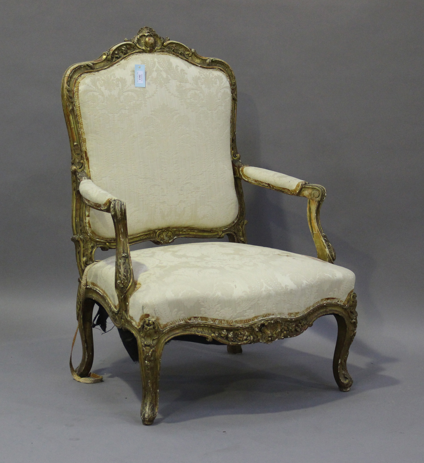 A 19th century French giltwood showframe fauteuil armchair with carved scroll decoration, on