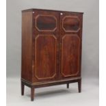 A 19th century figured mahogany cabinet, crossbanded in satinwood and enclosed by two doors, with