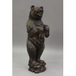 A 19th century Swiss Black Forest carved softwood stand, modelled in the form of a bear with inset
