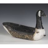 An early 20th century carved softwood decoy model of a Canada goose, height 34cm, length 59cm.