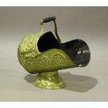 A Victorian brass helmet coal scuttle, embossed with foliate decoration, length 46cm.Buyer’s Premium