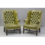 A pair of 20th century George III style wing back armchairs, upholstered in buttoned green