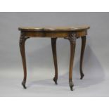 A mid-Victorian walnut fold-over card table with foliate inlaid decoration, on carved cabriole legs,