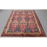 A Kurdish carpet, 20th century, the pink field with offset rows of shaped medallions, within a