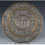 A 19th century Indian white metal mounted brass circular dish, decorated in embossed relief,