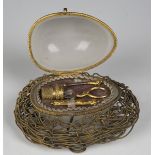 An early 20th century opaline glass and metal mounted nécessaire, modelled in the form of an egg