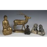 A pair of 20th century Eastern grey soap stone models of temple dogs, together with a brass model of