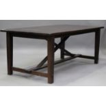 A modern hardwood rectangular dining table, raised on block legs united by an 'X'-frame support,