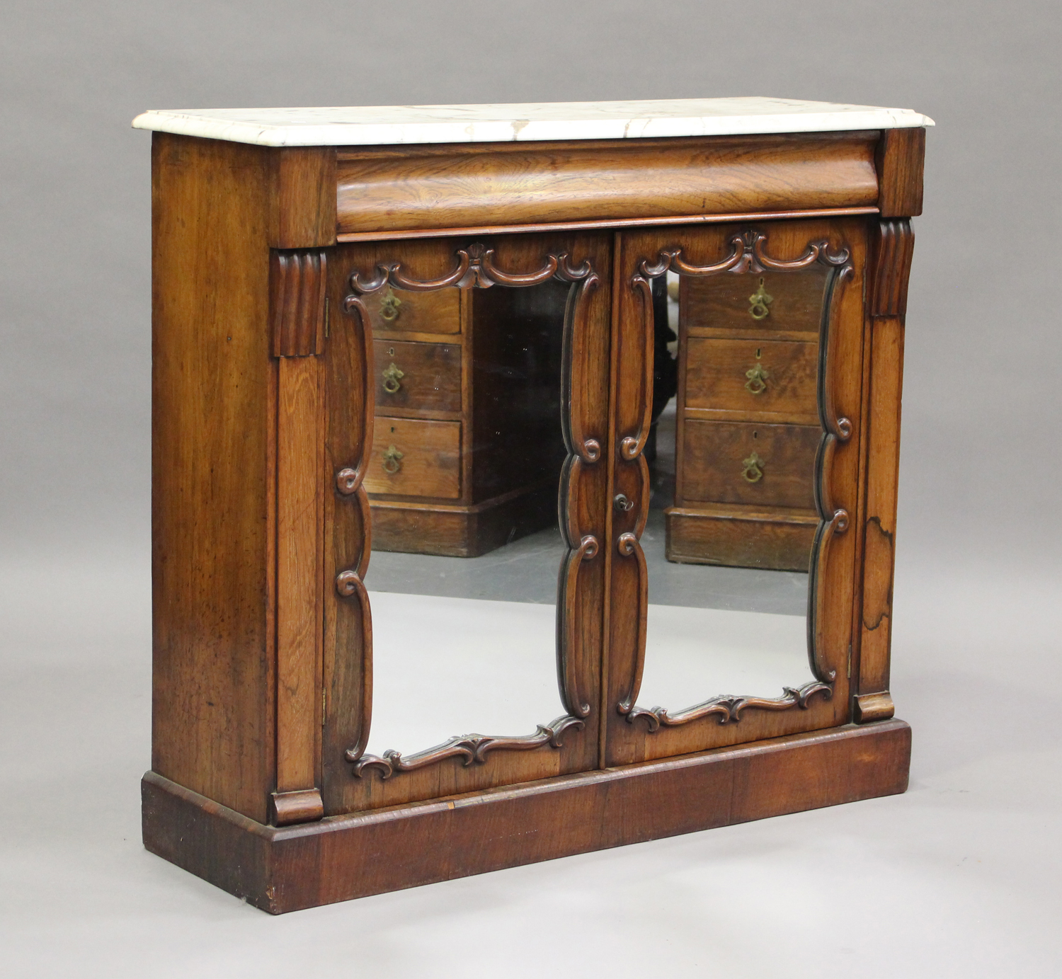 A Victorian rosewood and white marble-topped side cabinet, fitted with a pair of mirrored doors,