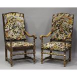 A pair of early 20th century Carolean style oak arched back armchairs, each with needlework seat and