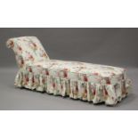 A late Victorian daybed, upholstered in a printed floral fabric with a cream ground, on turned