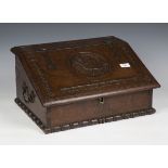 An 18th century and later bible box with carved decoration, the sloped hinged lid above carrying