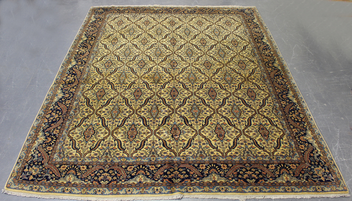 An Indian carpet, mid/late 20th century, the ivory field with an overall floral lattice, within a