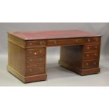 A Victorian mahogany twin pedestal desk, the top inset with gilt-tooled red leather, above an