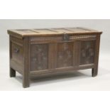 An early 18th century panelled oak coffer with carved decoration, the hinged lid on stile
