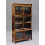 An early 20th century walnut glazed sectional bookcase by Minty, on turned feet, height 168cm, width