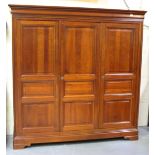 A modern cherrywood wardrobe, the moulded pediment above panelled doors, on a plinth base, height