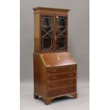 An Edwardian mahogany bureau bookcase with inlaid decoration, the fall front above drawers, on