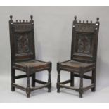 A pair of early 18th century oak panel back hall chairs with carved decoration, on turned and