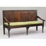 A George III oak settle with four panel back, on turned legs and pad feet, height 102cm, length
