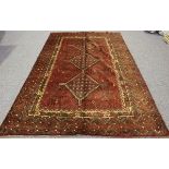 A Shiraz carpet, South-west Persia, the claret field with three linked medallions, within a