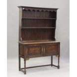 An early 20th century oak dresser, the shelf back above a cupboard, on turned and block legs, height
