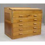 A mid-20th century oak two-section planner's chest, the sloped and hinged top above five drawers,