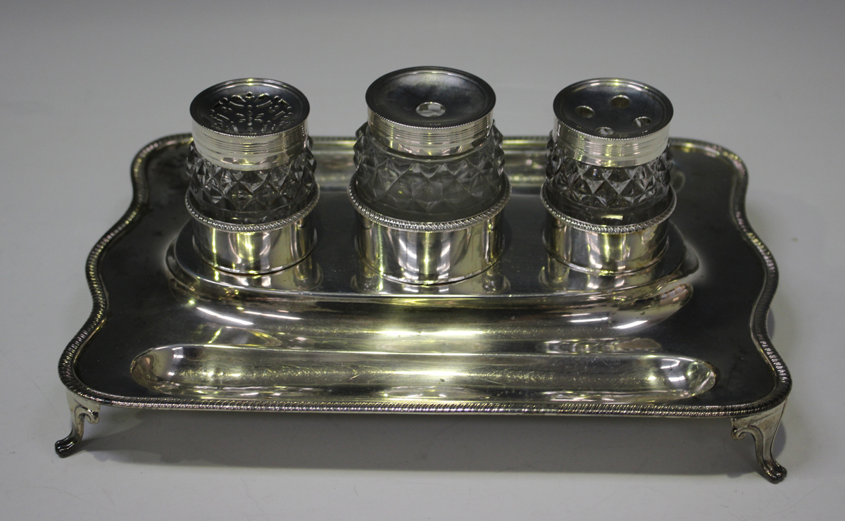 A George III silver inkstand of shaped rectangular form with gadrooned rim and two pen recesses,