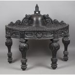 An early 20th century Ceylonese ebony demi-lune table, the shaped gallery back centred by a turned