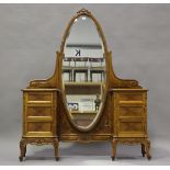 An early 20th century French walnut dressing table with oval swing frame mirror, fitted with drawers