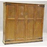 An early 20th century scumbled softwood housekeeper's cupboard, fitted with two double-hinged