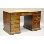 A 20th century mahogany twin pedestal desk, the top inset with tooled leather above an arrangement