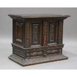 An 18th century Continental carved oak table-top cabinet, profusely carved with bands of foliage,