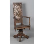 An 18th century Continental walnut revolving armchair, the arched panel back finely carved with