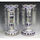 A pair of Bohemian blue glass and white flash overlay table lustres, late 19th century, painted with