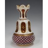 A Bohemian white flash overlay cranberry glass vase, late 19th century, the pear shaped body cut