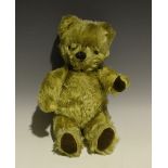 A mid-20th century mohair teddy bear with amber and black eyes, vertically stitched nose and jointed