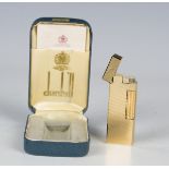 A Dunhill gold plated rectangular gas lighter, with engine turned decoration, length 6.3cm, together
