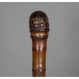 A late 19th century Japanese bamboo walking cane, carved in overall relief with birds and foliage,
