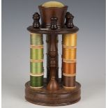 A 20th century mahogany needlework spool holder with pin cushion surmount and lidded compartment