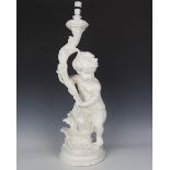 A 20th century white painted cast plaster table lamp in the form of a putto holding a cornucopia