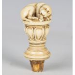 An 18th century ivory walking cane handle, the top finely modelled as a recumbent dog above a