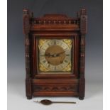 A late 19th century Arts and Crafts style oak mantel clock with eight day movement striking on two