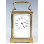 An early 20th brass cased carriage timepiece, the enamelled dial with black Roman hour numerals, the