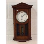 An early 20th century French oak cased electric wall clock, the circular dial with Arabic hours