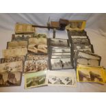 An old hand-held steroscopic viewer and a selection of various stereoscopic photographic cards