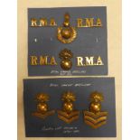 A small collection of Royal Marine Artillery badges including three brass pillbox cap insignia