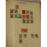 A folder album containing a collection of British West Indies stamps including Antigua, Cayman,