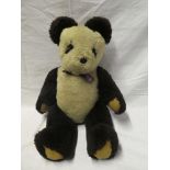 A vintage plush covered panda